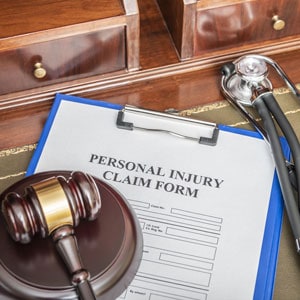 Personal injury claim form with a gavel and stethoscope, symbolizing legal and medical aspects of claims - Hobaica Law Office.